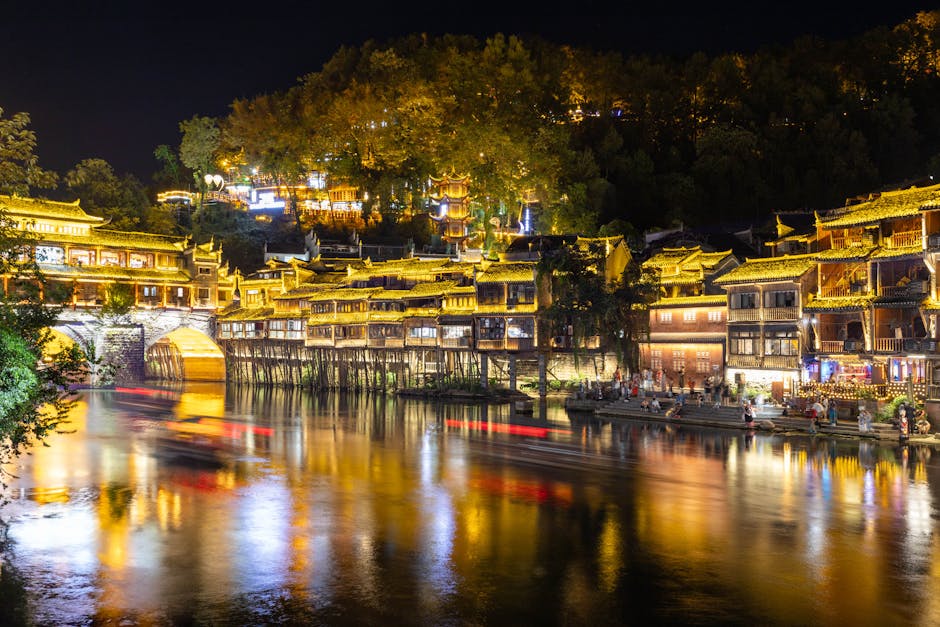 Fenghuang iluminado de noche con sus casas sobre el río Tuojiang